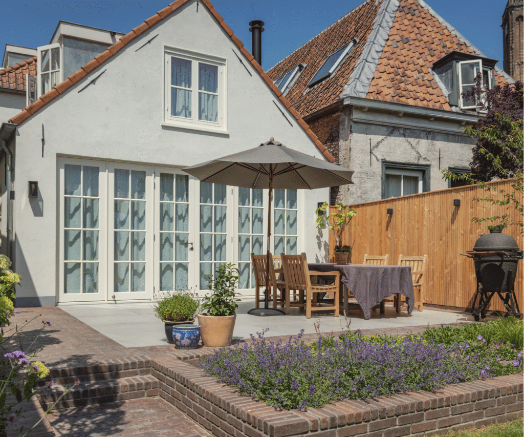 luxe achtertuin inspiratie. Terras met stoelen, tafel en parasol