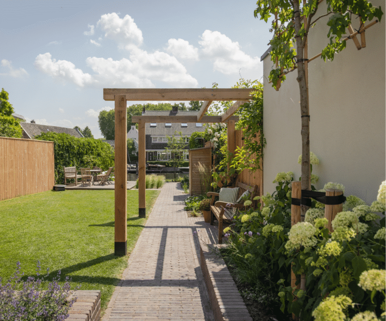 Lange achtertuin met looppad, pergola, zitplekken en gras
