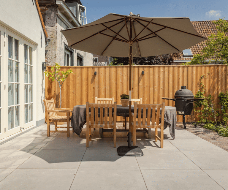 luxe terras in achtertuin met stoelen, tafel en parasol