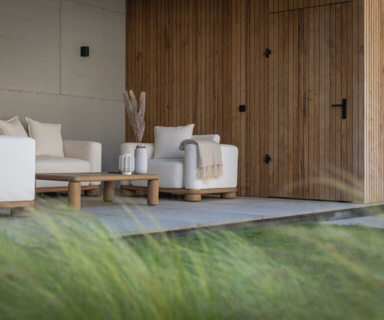 Luxe overkapping met zithoek en uitzicht op de groene achtertuin